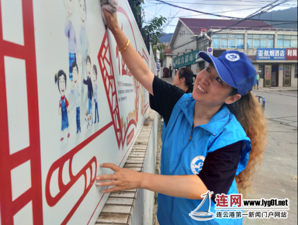 党员志愿者清理宣传栏 巩固创文成果
